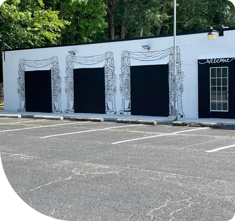 A parking lot with three garage doors on the side of it.